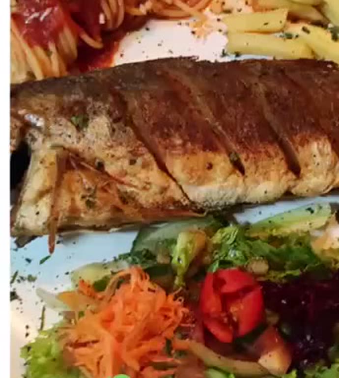Pescado frito entero con papas y ensalada fresca